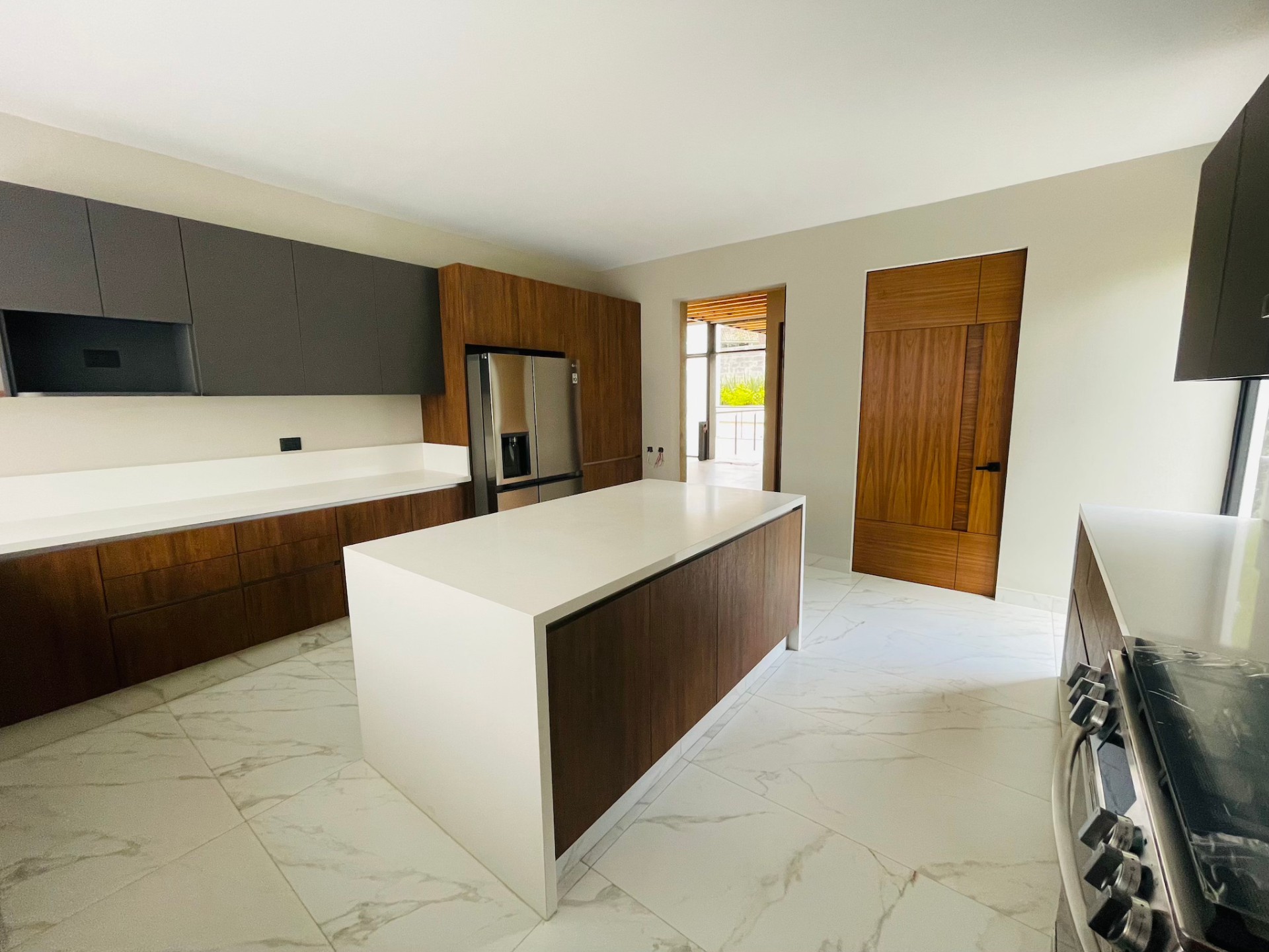 Cocina con barra de mármol y carpintería de madera